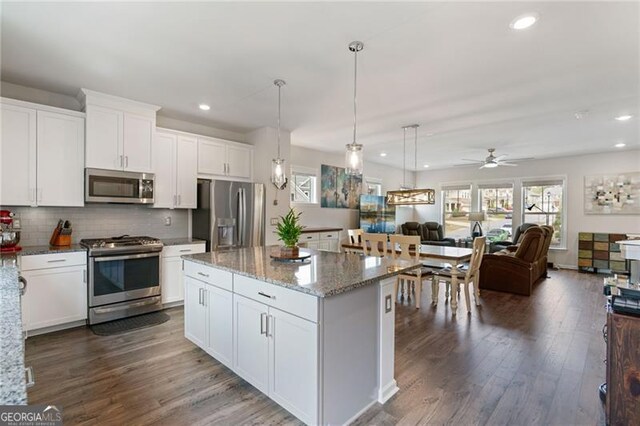 kitchen featuring dark wood-style flooring, open floor plan, white cabinets, ceiling fan, and appliances with stainless steel finishes