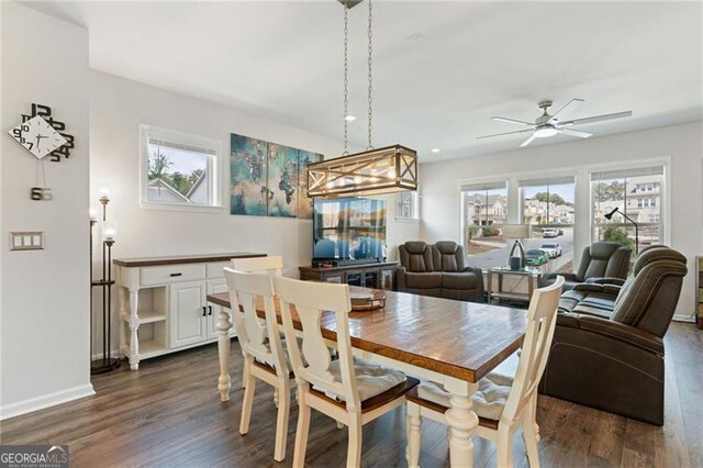 dining room with dark wood-style flooring, a ceiling fan, and a healthy amount of sunlight