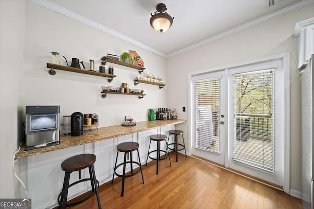 bar featuring crown molding and hardwood / wood-style floors
