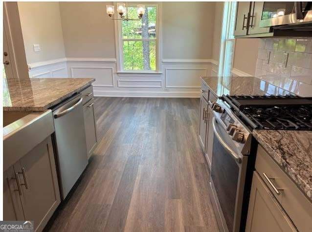 3383 Milan Court Lot 4; Plapprox Sqft 1, Douglasville, GA 30135 - kitchen with stainless steel appliances, a wainscoted wall, a chandelier, light stone counters, and dark wood-style floors