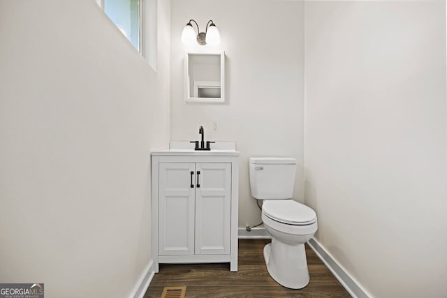262 E Main St, Rutledge, GA 30663 - half bath with toilet, baseboards, visible vents, vanity, and wood finished floors
