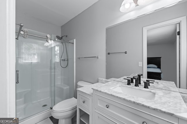 bathroom with vanity, a stall shower, toilet, and ensuite bath