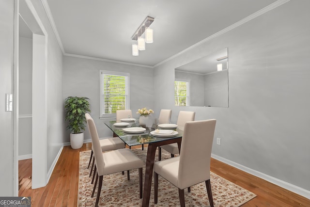 dining space with baseboards, ornamental molding, and wood finished floors