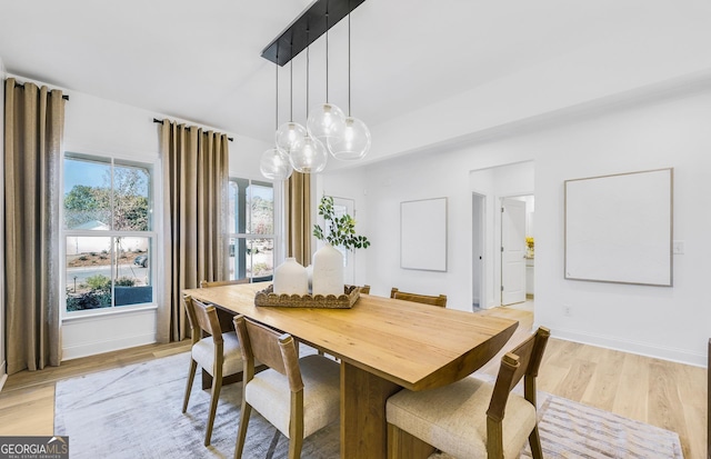 dining space with baseboards and light wood-type flooring