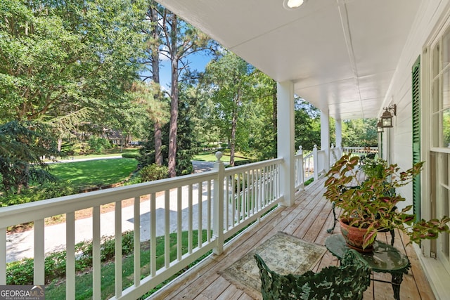 deck featuring a porch and view of scattered trees