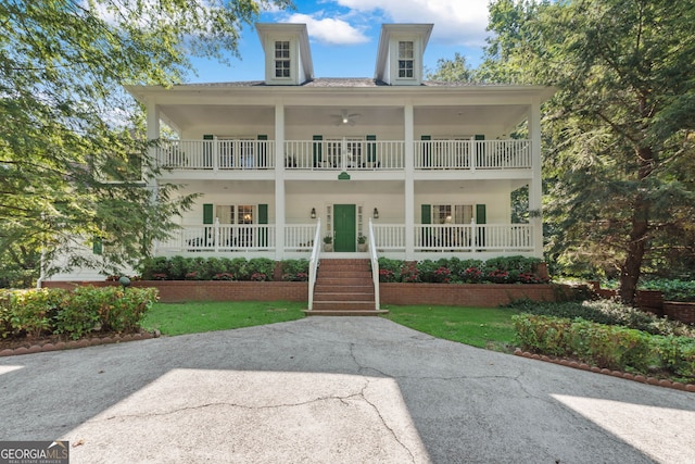 view of front facade featuring a porch, a balcony, and stairway
