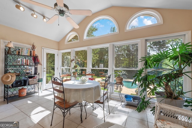 sunroom / solarium featuring tile patterned flooring and high vaulted ceiling