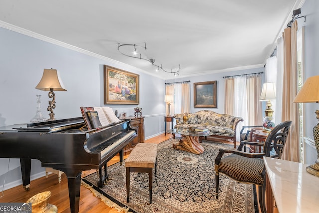 living area with crown molding, wood finished floors, and baseboards