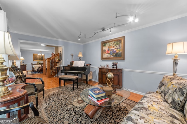 living area featuring wood finished floors, ornamental molding, rail lighting, and baseboards