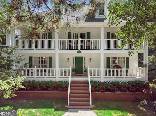 view of front of property with covered porch, a balcony, and a shingled roof