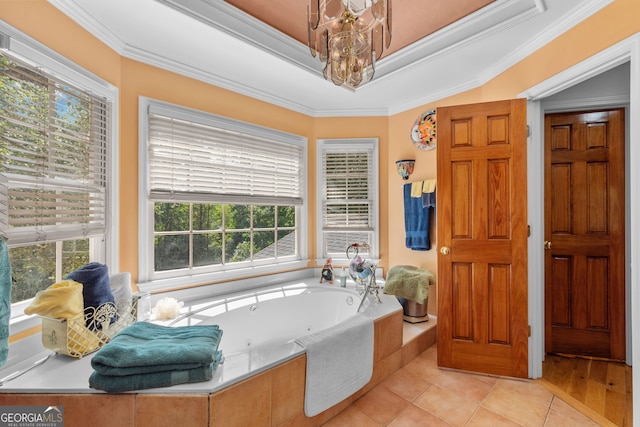 bathroom with healthy amount of natural light, crown molding, a tub with jets, a chandelier, and a tray ceiling