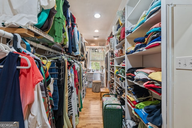 walk in closet with wood finished floors