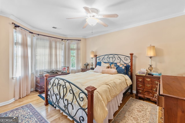 bedroom with light wood-type flooring, crown molding, baseboards, and ceiling fan