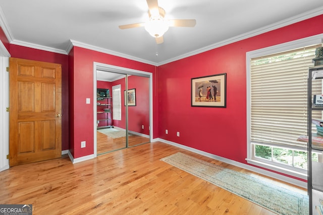 unfurnished bedroom with light wood-type flooring, baseboards, crown molding, a closet, and a ceiling fan