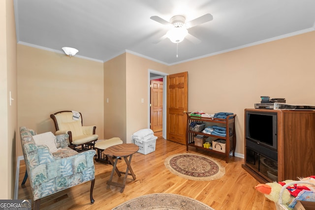 living area with wood finished floors, crown molding, and a ceiling fan