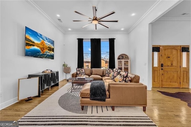 living room with baseboards, crown molding, visible vents, ceiling fan, and wood finished floors