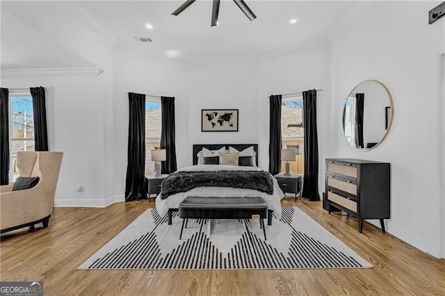bedroom with visible vents, multiple windows, ornamental molding, and wood finished floors