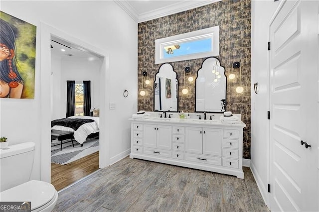full bath with a sink, toilet, crown molding, double vanity, and wood finished floors