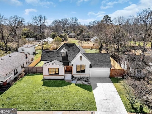 modern inspired farmhouse featuring a garage, roof with shingles, a front yard, fence, and concrete driveway