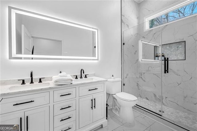 bathroom with double vanity, toilet, a marble finish shower, marble finish floor, and a sink
