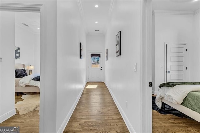 corridor with crown molding, visible vents, recessed lighting, wood finished floors, and baseboards