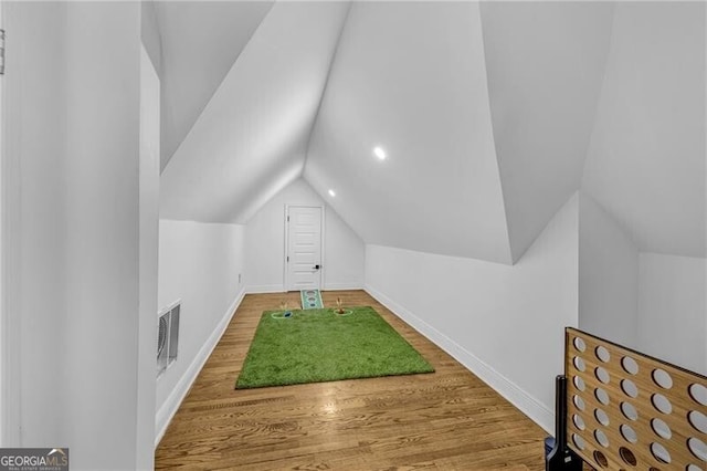 bonus room featuring visible vents, baseboards, wood finished floors, and lofted ceiling