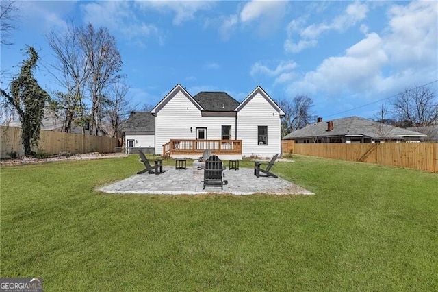 rear view of property featuring a patio, a yard, a fenced backyard, and an outdoor fire pit