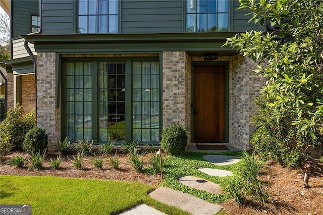 doorway to property featuring brick siding