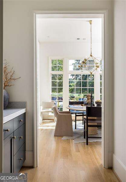 interior space featuring light wood-type flooring and an inviting chandelier