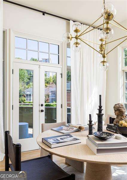 dining area with french doors, an inviting chandelier, and wood finished floors