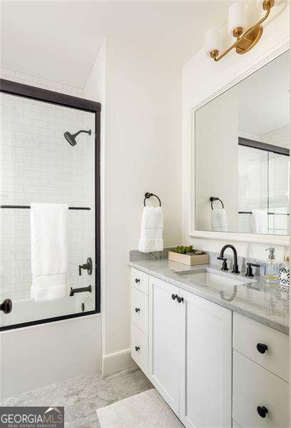 full bath with shower / bath combination with glass door and vanity