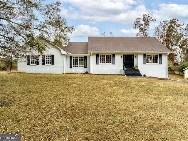 ranch-style home featuring brick siding, a shingled roof, and a front lawn