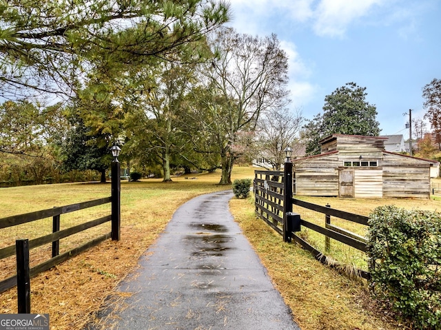 view of street with aphalt driveway, street lighting, and a barn
