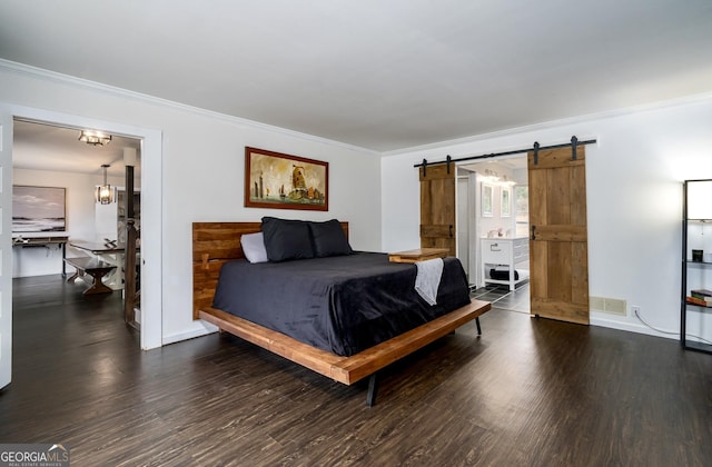 bedroom featuring a barn door, wood finished floors, visible vents, and ornamental molding