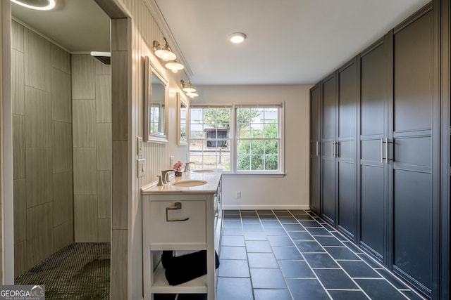 full bath with a tile shower, baseboards, tile patterned floors, and vanity