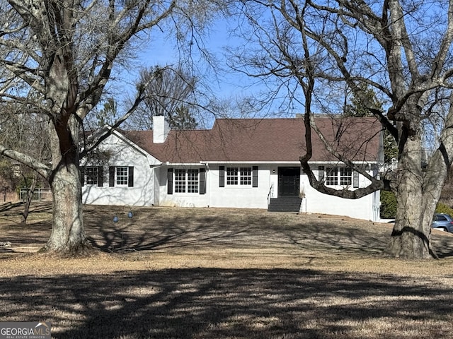 view of front of house with a chimney and stucco siding