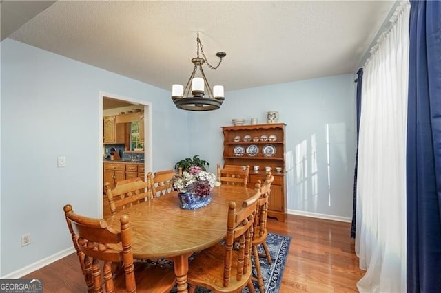 209 Red Fern Ct, Canton, GA 30114 - dining area featuring light wood-type flooring, a chandelier, baseboards, and a textured ceiling