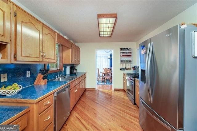 209 Red Fern Ct, Canton, GA 30114 - kitchen featuring appliances with stainless steel finishes, a sink, light wood finished floors, dark countertops, and baseboards