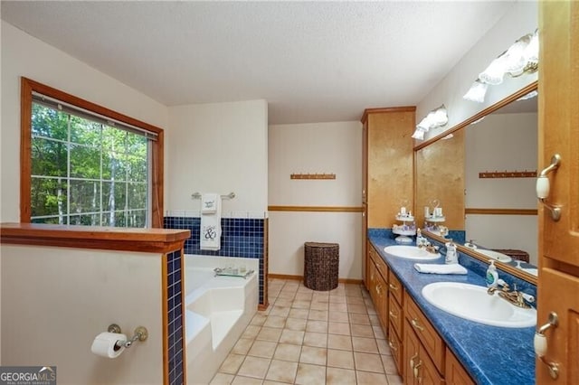 209 Red Fern Ct, Canton, GA 30114 - bathroom featuring tile patterned floors, double vanity, a bath, a textured ceiling, and baseboards