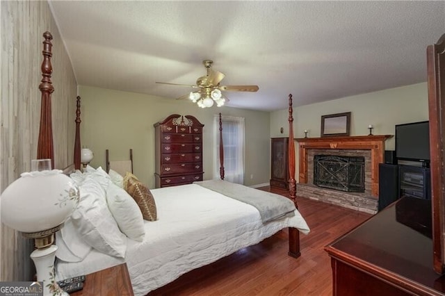 209 Red Fern Ct, Canton, GA 30114 - bedroom featuring wood finished floors, a stone fireplace, a ceiling fan, and baseboards