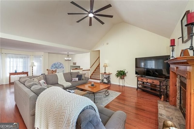 209 Red Fern Ct, Canton, GA 30114 - living area featuring ceiling fan, a fireplace with raised hearth, a chandelier, wood finished floors, and stairs