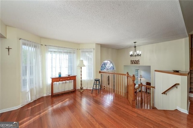 209 Red Fern Ct, Canton, GA 30114 - empty room featuring wood finished floors, a chandelier, and a textured ceiling