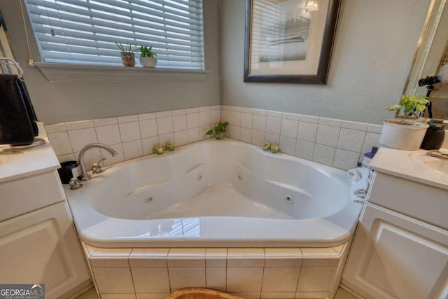 bathroom with vanity and a tub with jets