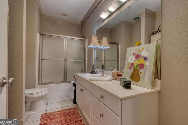 bathroom with tile patterned flooring, ornamental molding, a textured wall, vanity, and toilet