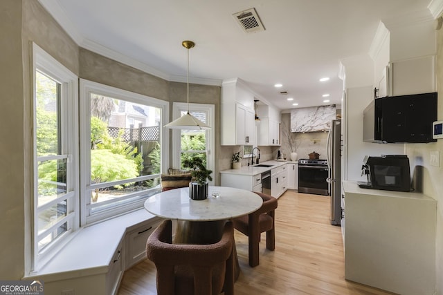 dining room with recessed lighting, visible vents, light wood-type flooring, and crown molding