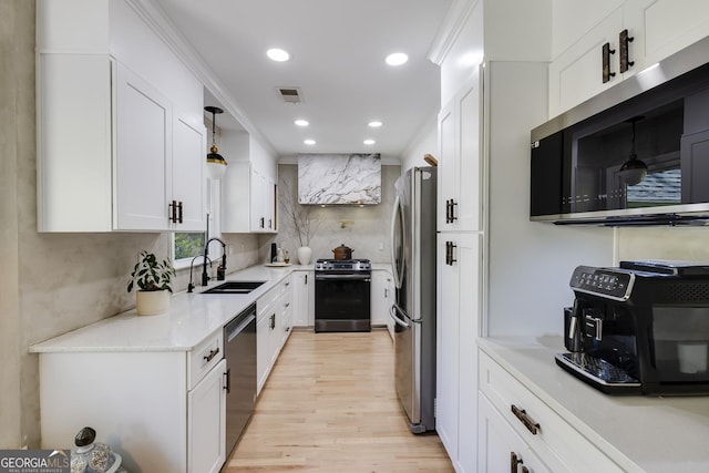 kitchen with light wood-type flooring, white cabinetry, visible vents, a sink, and stainless steel appliances