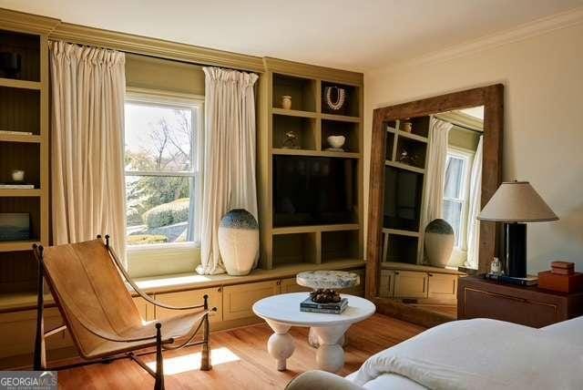 living area featuring crown molding and wood finished floors