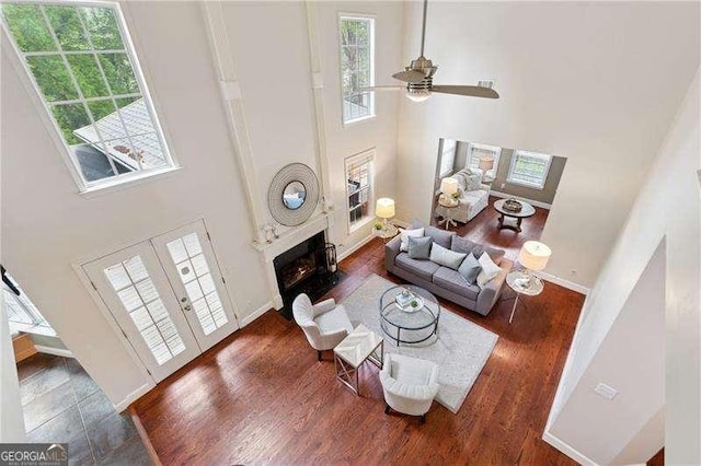 310 Kingspring Ct, Roswell, GA 30076 - living area with a fireplace, a high ceiling, a ceiling fan, and wood finished floors