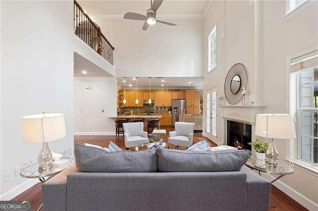 310 Kingspring Ct, Roswell, GA 30076 - living area with a glass covered fireplace, baseboards, a ceiling fan, and dark wood finished floors