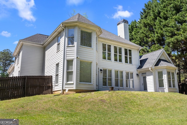 774 Mary Ann Dr NE, Marietta, GA 30068 - back of house featuring roof with shingles, a chimney, fence, and a lawn